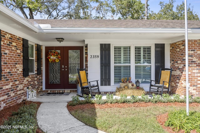 view of exterior entry featuring french doors and covered porch