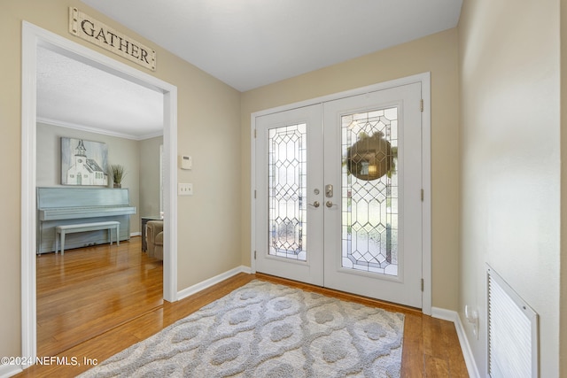 foyer entrance with french doors and hardwood / wood-style floors