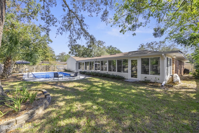 back of house featuring a fenced in pool, a yard, and a sunroom