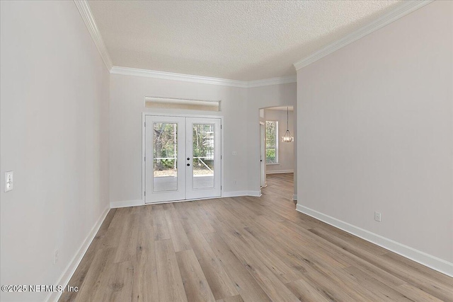 empty room featuring french doors, crown molding, light hardwood / wood-style floors, and a textured ceiling