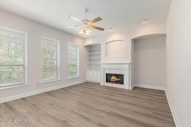 unfurnished living room featuring hardwood / wood-style flooring, a fireplace, and a textured ceiling