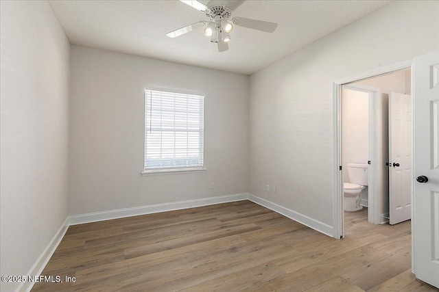 empty room with ceiling fan, a textured ceiling, and light hardwood / wood-style floors