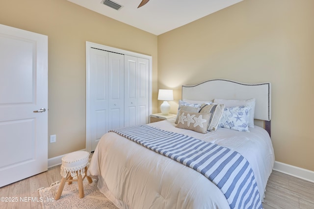 bedroom featuring ceiling fan, light hardwood / wood-style floors, and a closet