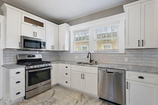 kitchen featuring stainless steel appliances, sink, decorative backsplash, and white cabinets