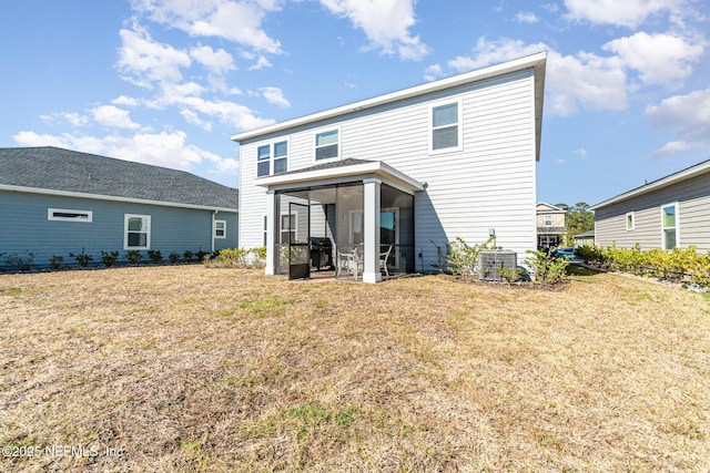 back of property featuring a lawn and a sunroom