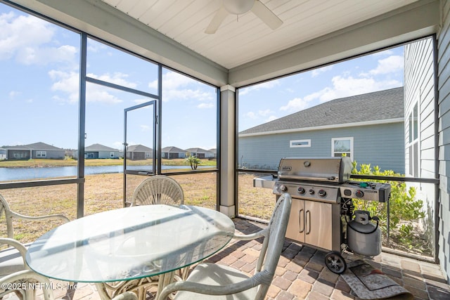 sunroom with a water view, ceiling fan, and plenty of natural light