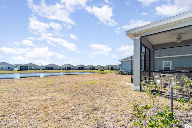 view of yard featuring a water view and ceiling fan