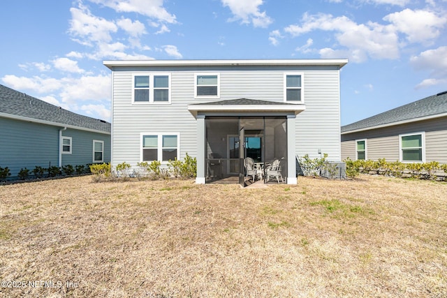 back of property with a sunroom and a yard