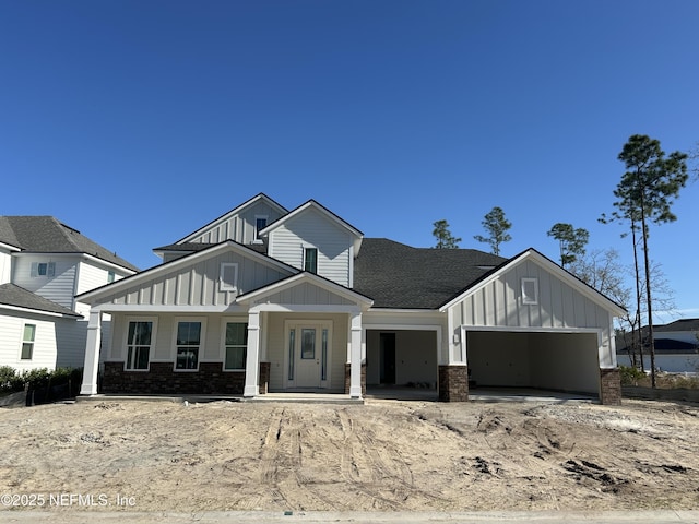 view of front of property featuring roof with shingles, board and batten siding, and an attached garage