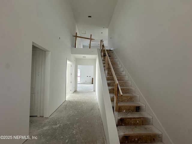 staircase featuring a towering ceiling