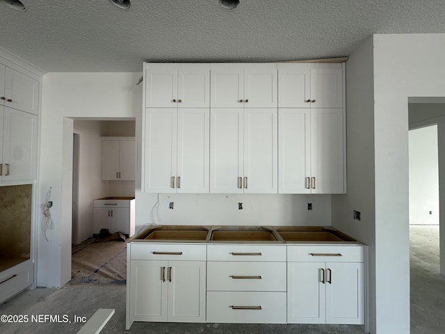 kitchen with white cabinetry and a textured ceiling