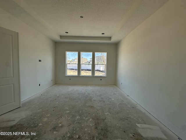 empty room with a raised ceiling and a textured ceiling