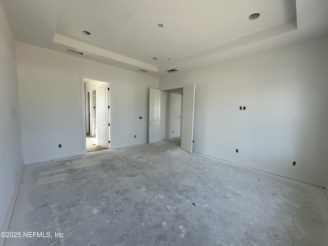 unfurnished bedroom with a raised ceiling, a textured ceiling, and baseboards