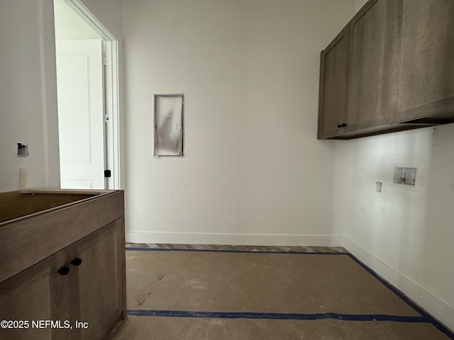 clothes washing area featuring cabinet space, baseboards, and washer hookup