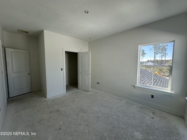 unfurnished bedroom featuring visible vents, a textured ceiling, and baseboards