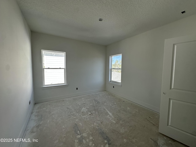 unfurnished room featuring baseboards and a textured ceiling