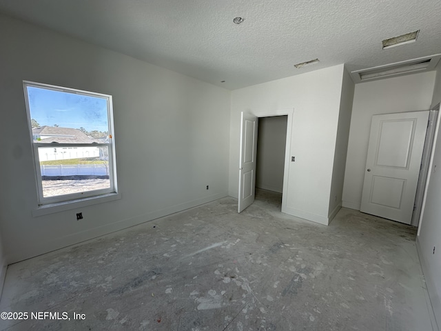 unfurnished bedroom featuring a textured ceiling, visible vents, and baseboards