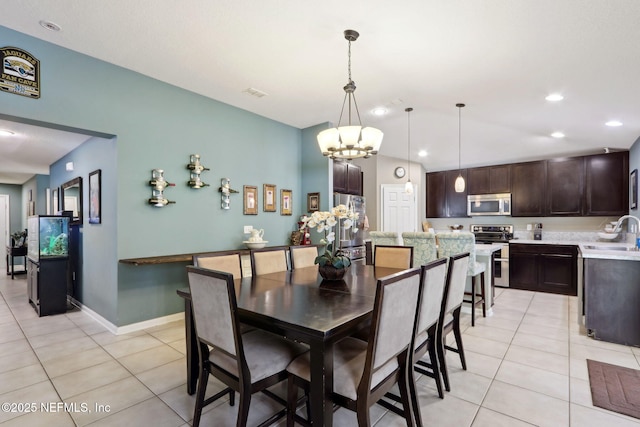 tiled dining area featuring lofted ceiling and sink