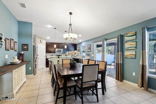 dining space featuring a notable chandelier and light tile patterned flooring