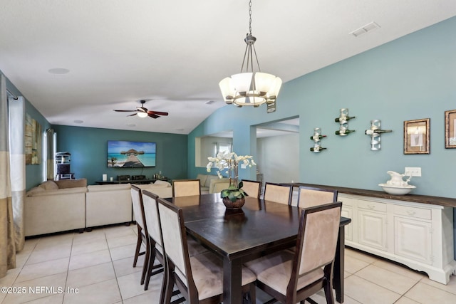 tiled dining space with vaulted ceiling and ceiling fan with notable chandelier