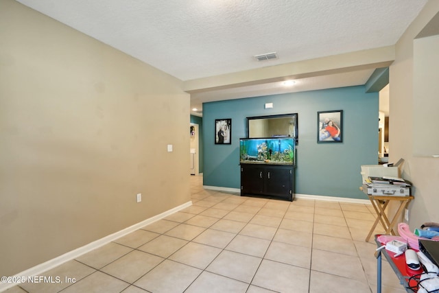 tiled living room featuring a textured ceiling