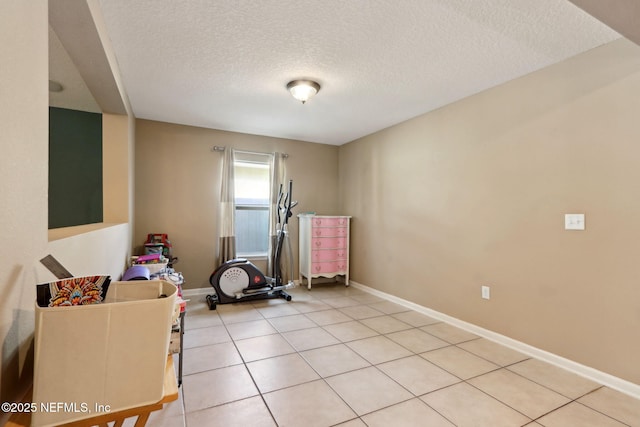 exercise room featuring a textured ceiling and light tile patterned floors