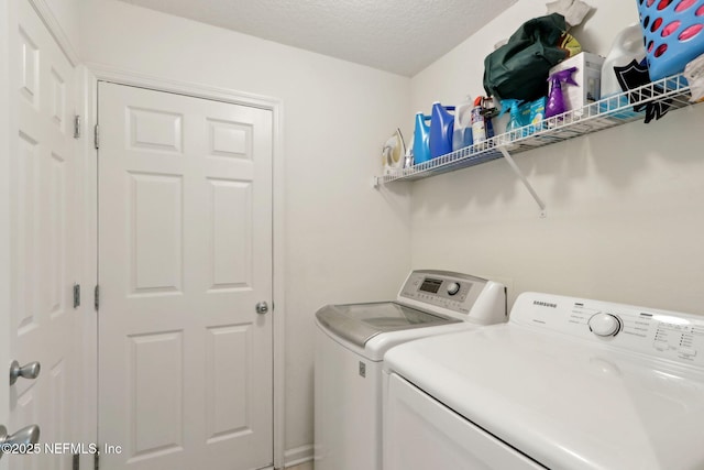 washroom with washing machine and dryer and a textured ceiling