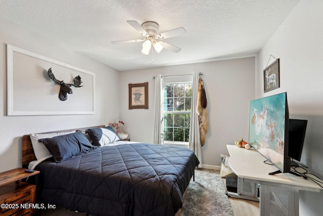 bedroom with ceiling fan and a textured ceiling