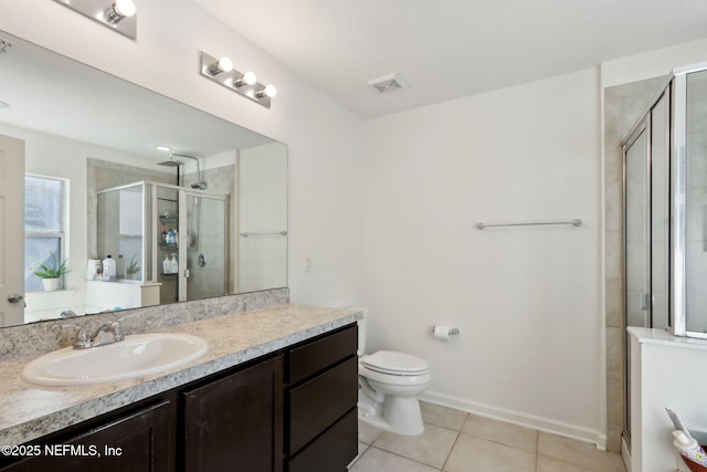 bathroom featuring tile patterned flooring, vanity, a shower with door, and toilet