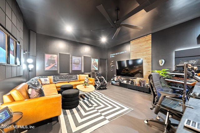 home theater room with light hardwood / wood-style floors and ceiling fan