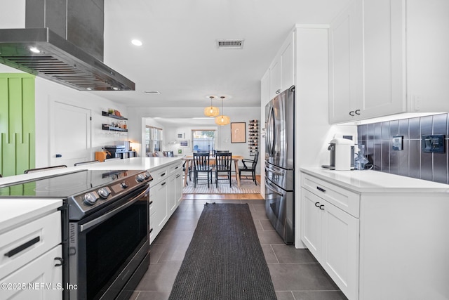 kitchen featuring dark tile patterned floors, appliances with stainless steel finishes, hanging light fixtures, white cabinets, and exhaust hood