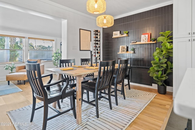 dining area with ornamental molding and light wood-type flooring