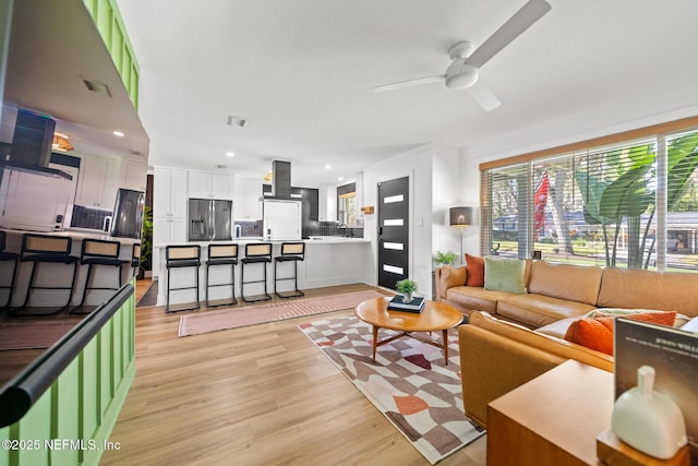 living room featuring ceiling fan and light hardwood / wood-style floors