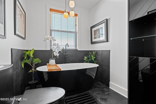 bathroom with a washtub and toilet