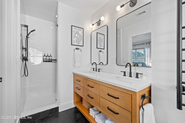 bathroom featuring tile patterned flooring, vanity, and a shower