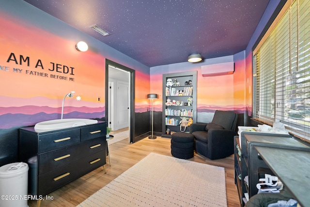 interior space featuring light hardwood / wood-style floors and an AC wall unit