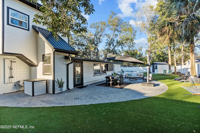 back of property with a storage shed, a yard, a patio area, and outdoor lounge area