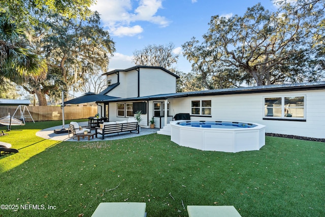 rear view of property featuring a patio, an outdoor hangout area, and a lawn