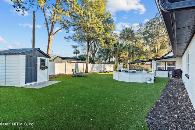 view of yard with a fenced in pool and a shed