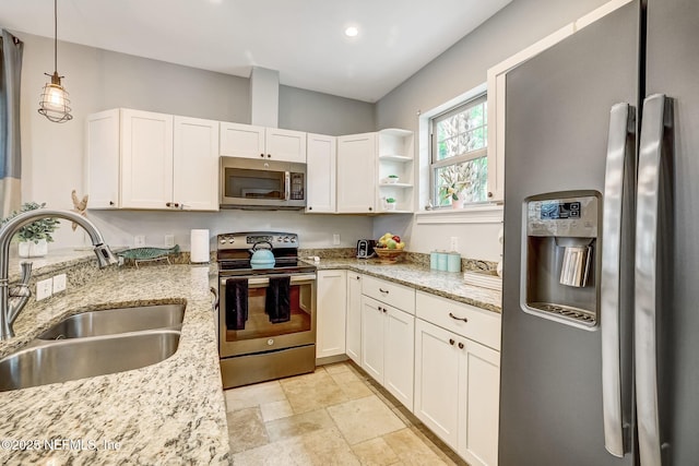 kitchen with white cabinetry, stainless steel appliances, sink, and light stone counters