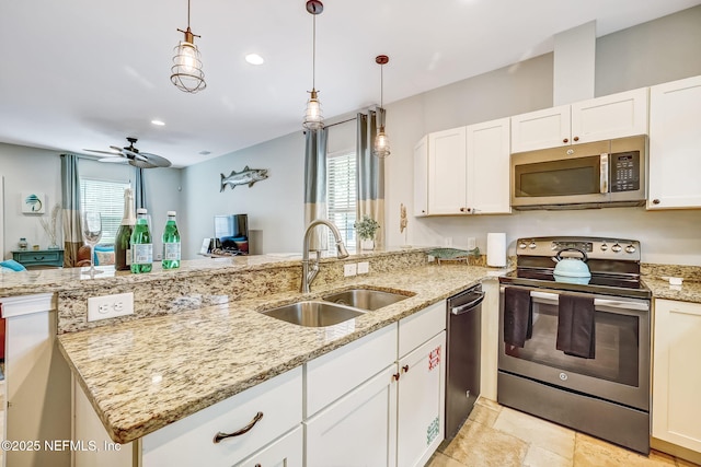 kitchen featuring pendant lighting, sink, white cabinetry, stainless steel appliances, and light stone countertops