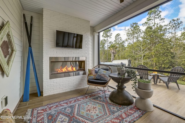 wooden terrace featuring an outdoor brick fireplace