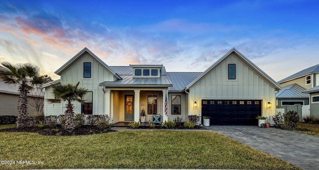 modern farmhouse style home featuring a garage, a porch, and a lawn