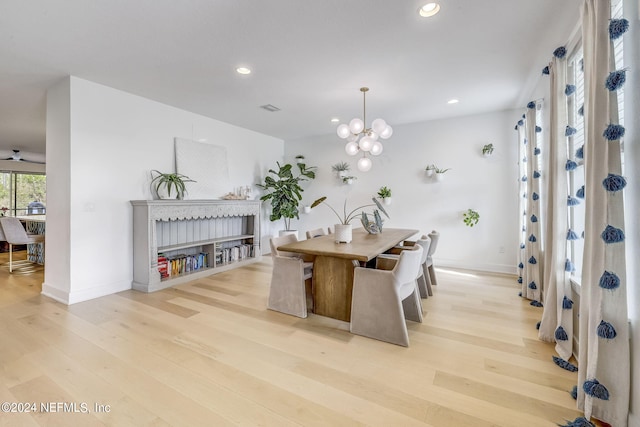 dining area with a notable chandelier and light hardwood / wood-style floors