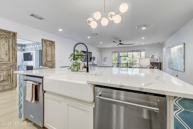 kitchen with white cabinetry, dishwasher, and light stone counters