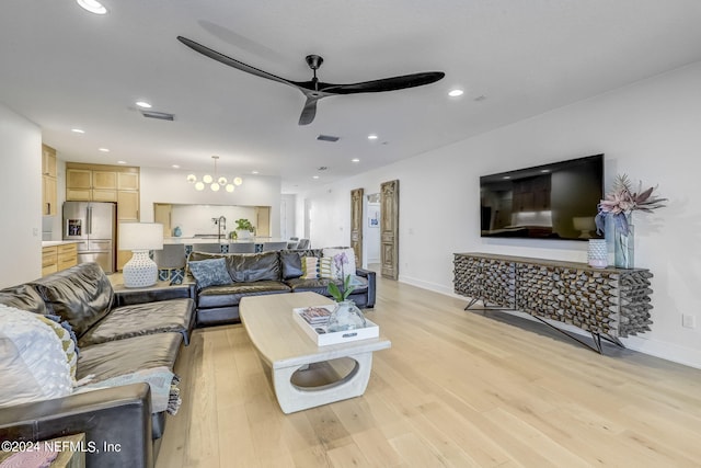 living room featuring sink, ceiling fan, and light wood-type flooring