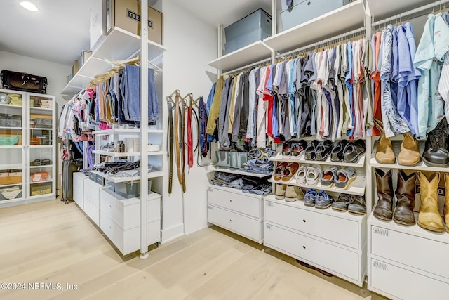 walk in closet with light hardwood / wood-style flooring