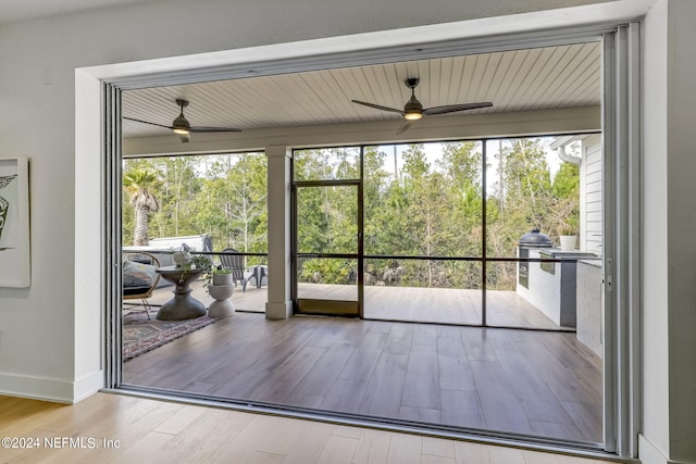 doorway featuring ceiling fan, a healthy amount of sunlight, and light wood-type flooring