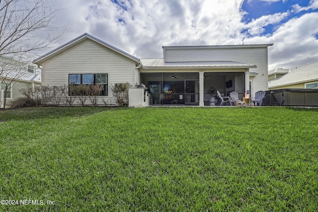 back of house featuring a yard, a sunroom, and ceiling fan