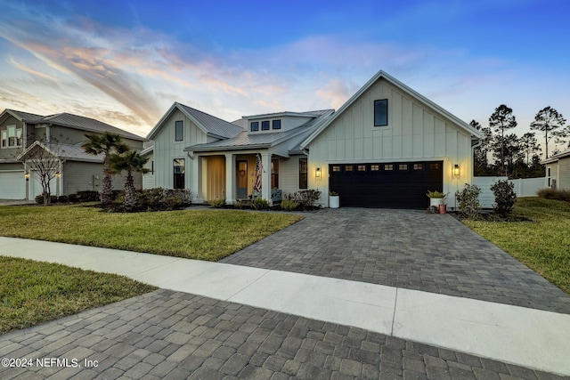 modern farmhouse style home with a garage and a yard